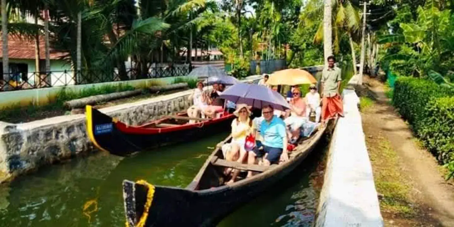 A canoe carrying guests along a narrow residential canal