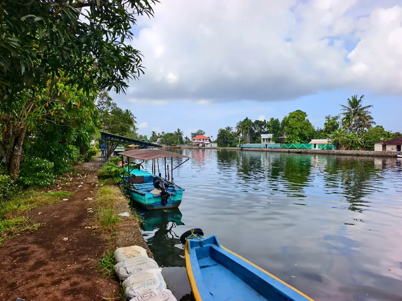 Small boats moored along a quiet Alleppey village canal