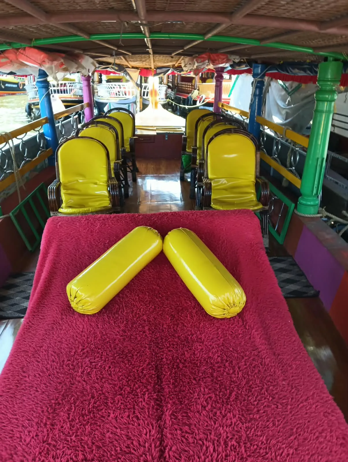 Front cushioned area and yellow chairs in a Shikara boat